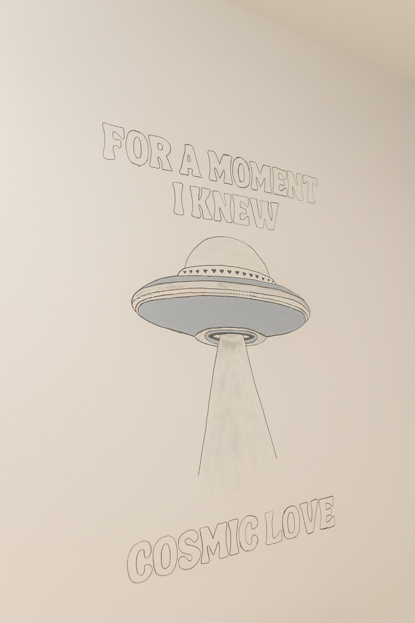 UFO illustration with text 'For a moment I knew cosmic love' on a beige background