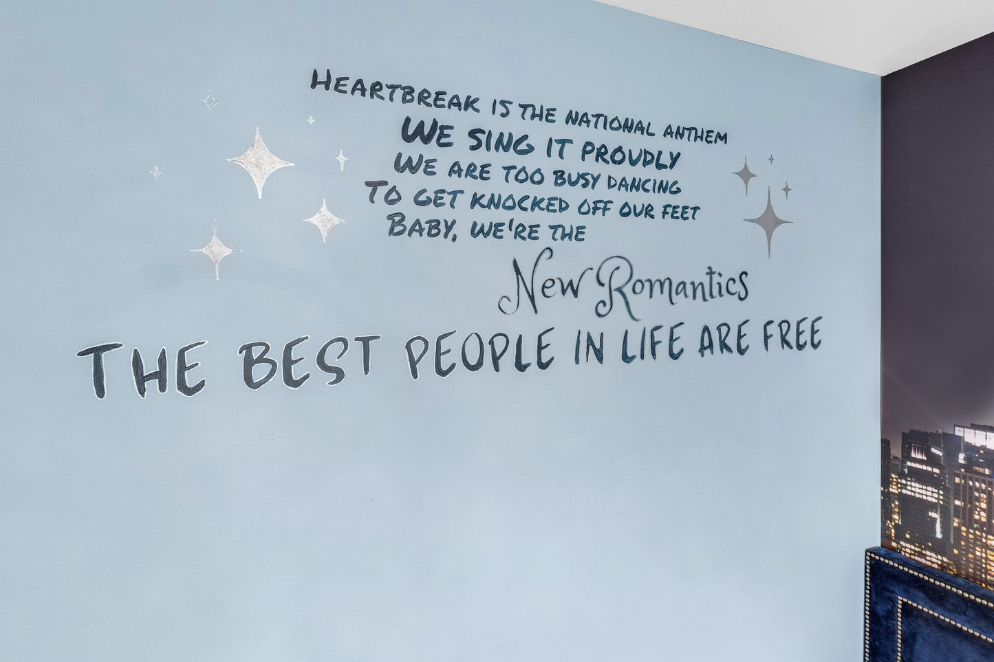 Wall with text and star decorations on a light blue wall.