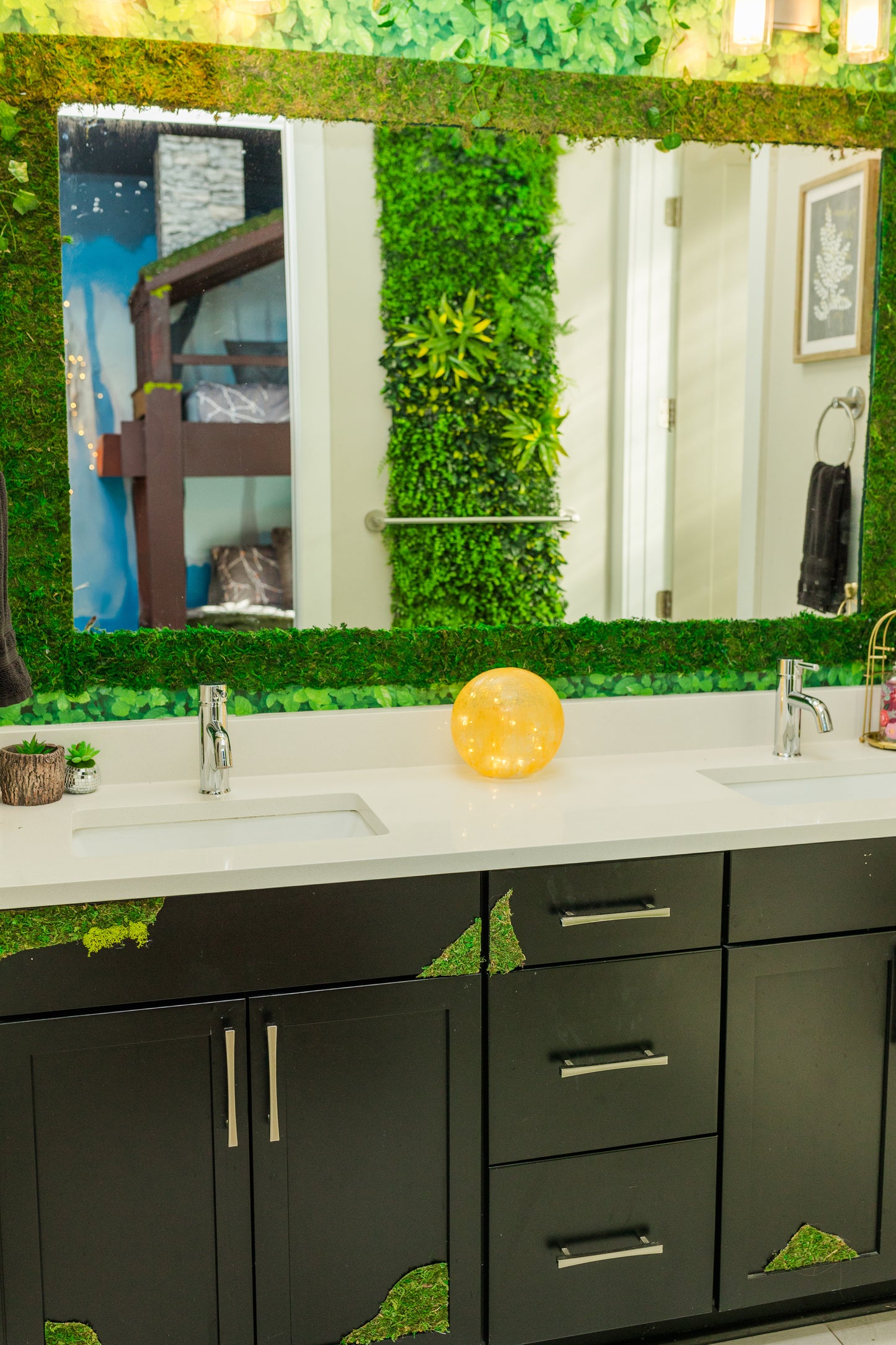 Bathroom vanity with green decorative elements and a large mirror.