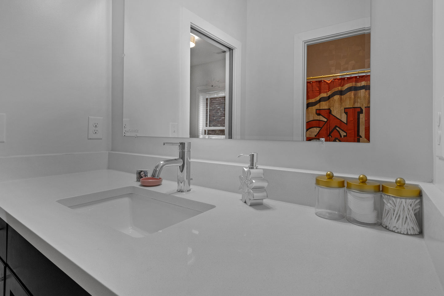 Bathroom vanity with sink, mirror, and decorative items.