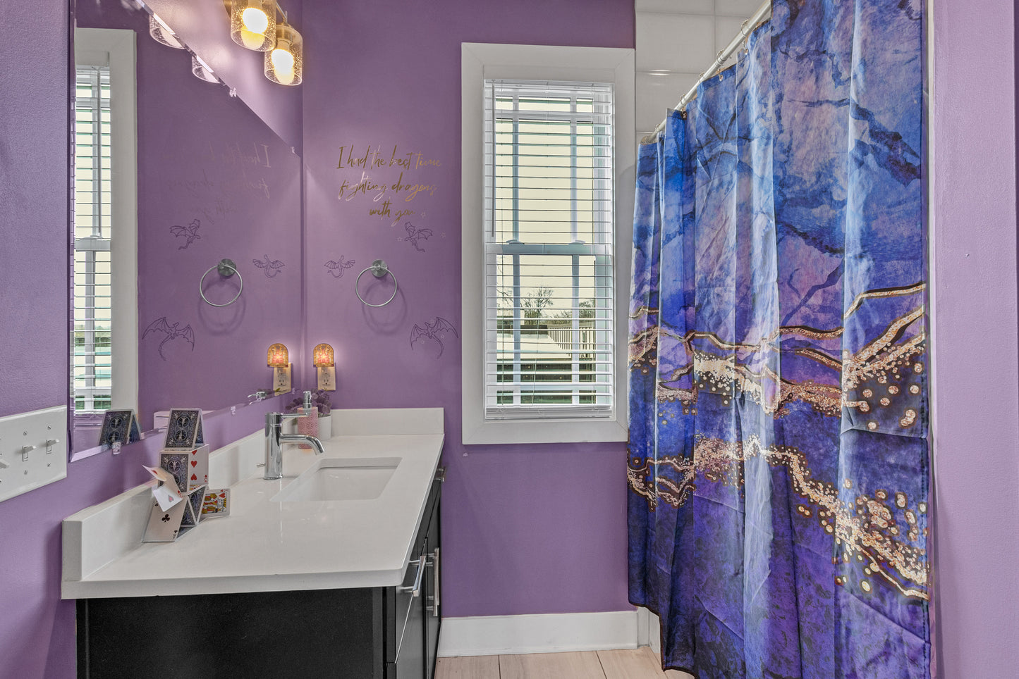 Bathroom with purple walls, a sink, and a decorative shower curtain.