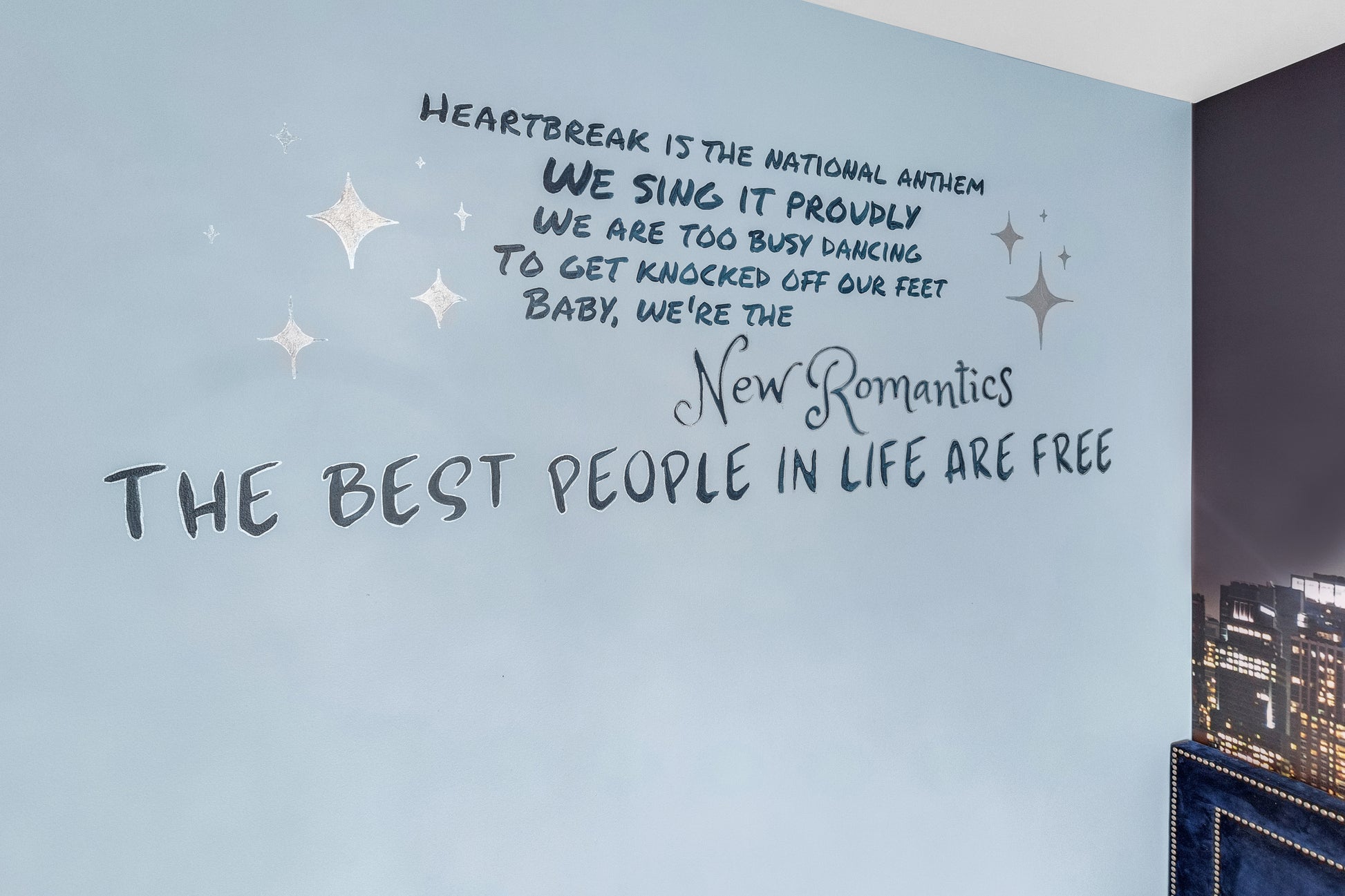 Wall with text and star decorations on a light blue wall.