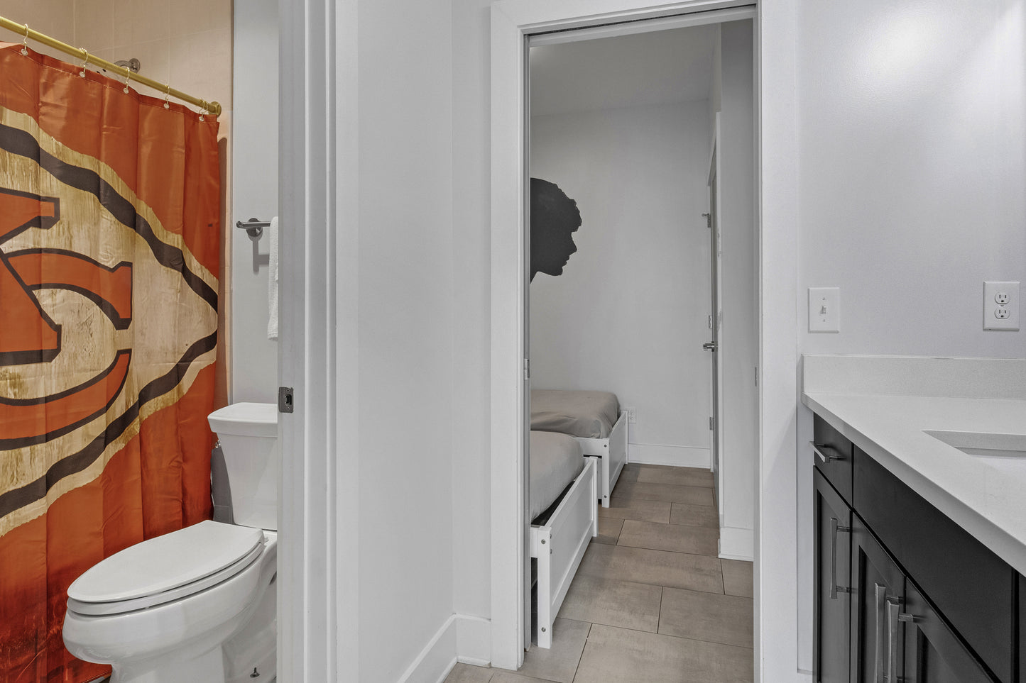 Bathroom with chiefs shower curtain, toilet, and sink.
